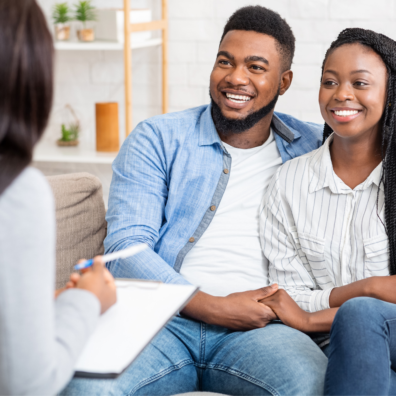 A Megawatt debt counsellor talking with a smiling couple during a consultation